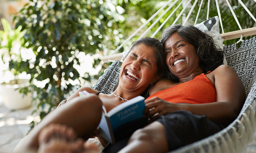 cheerful woman lying with mother in a hammock