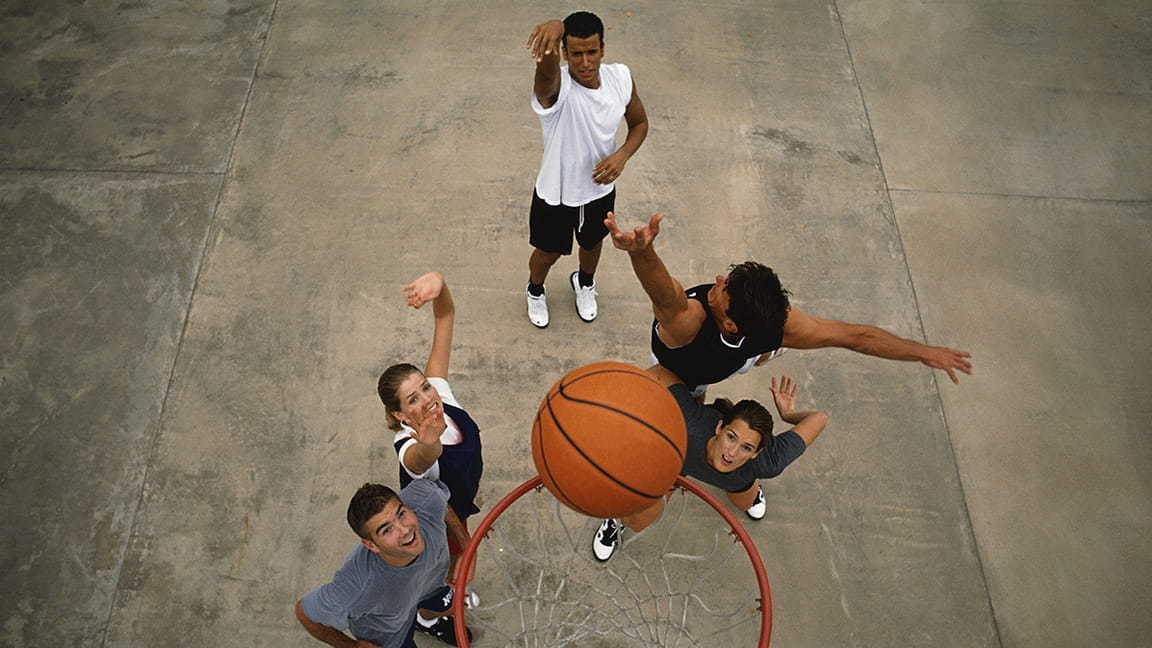 diverse friends playing basketball outdoors