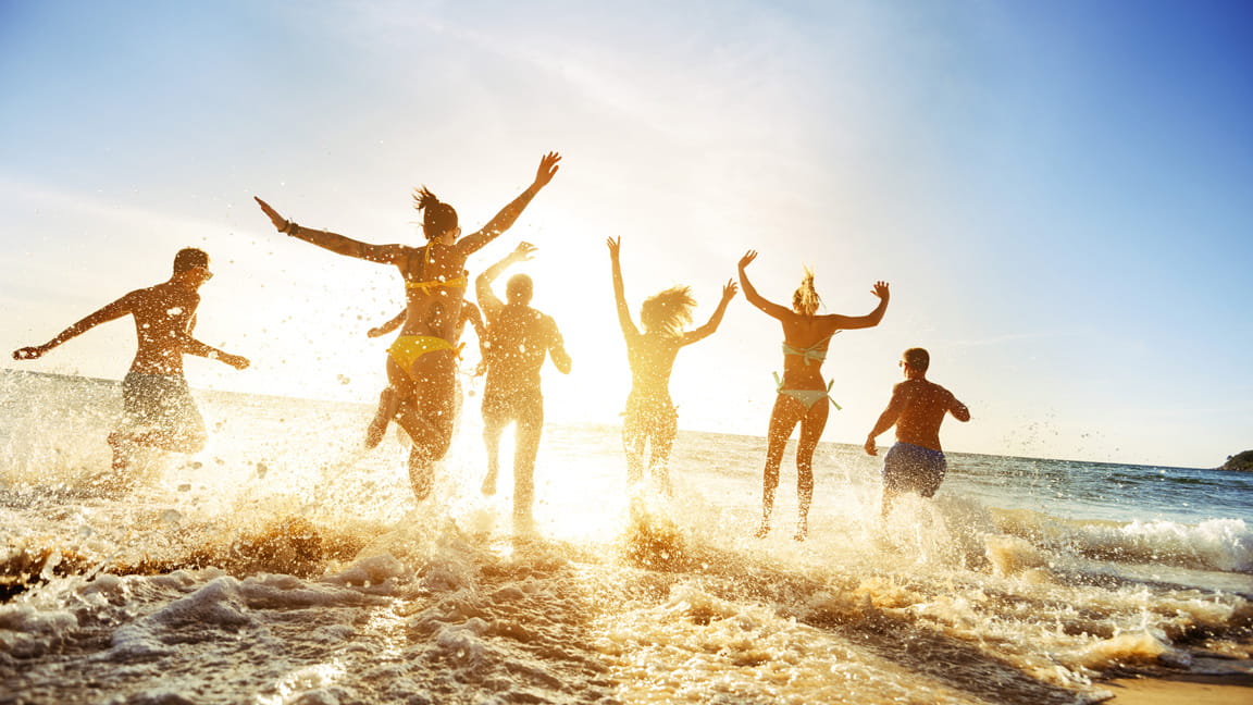 Millennial friends play on beach