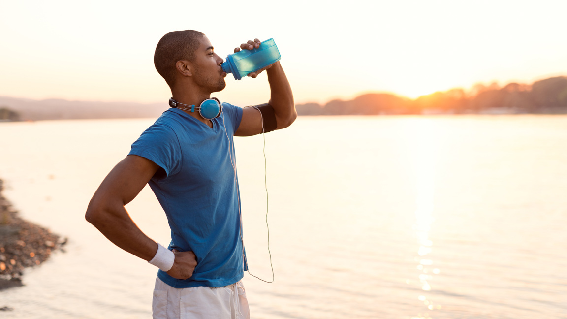 hombre bebiendo agua mientras hace ejercicio