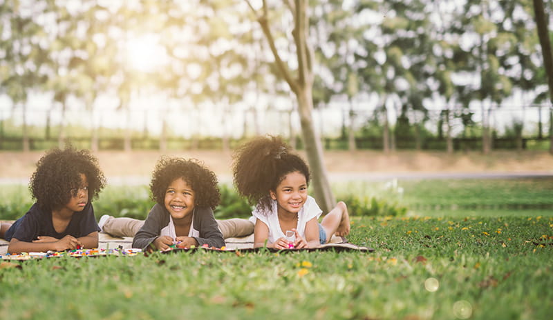 happy kids laying on blanket outdoors