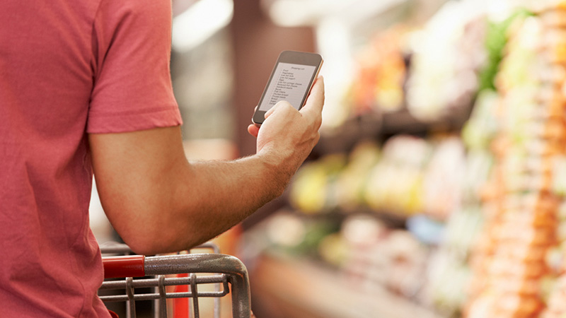 man looking at grocery list on phone