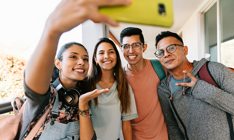 Estudiantes universitarios felices se toman una selfi al aire libre