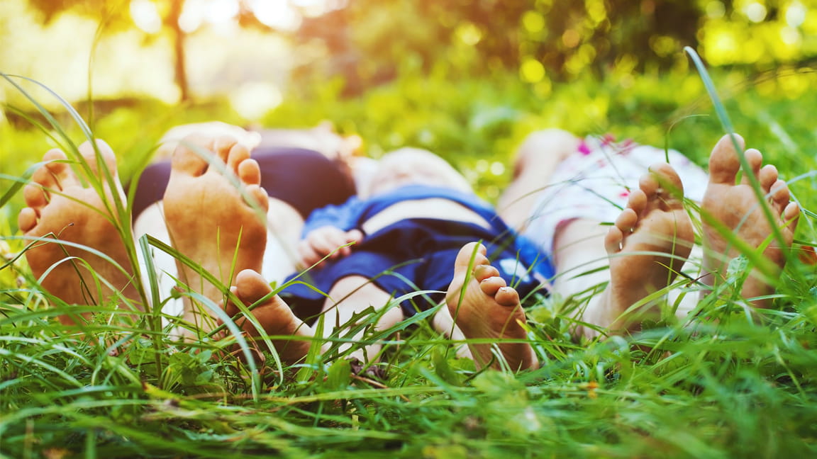 barefoot family laying in grass