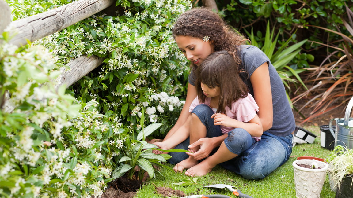 madre e hija plantando en el jardín