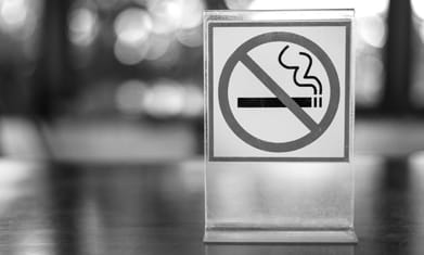 No smoking symbol sign sitting on table outdoors