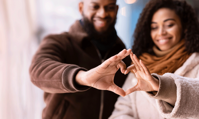 Couple making heart with hands during holidays