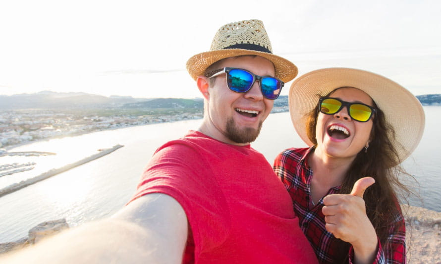 Man and women on beach taking a selfie