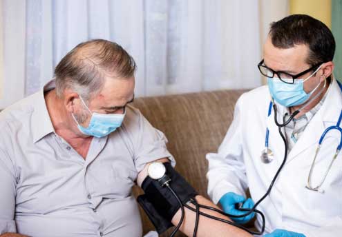 male patient having blood pressure checked by male doctor