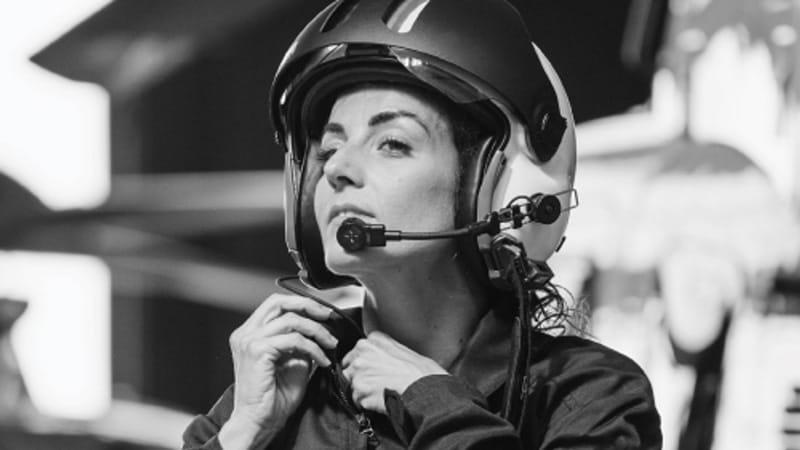 woman pilot adjusting her helmet