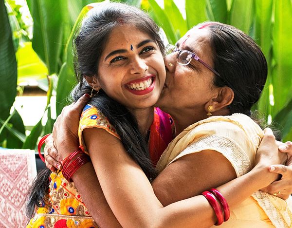 mother kissing adult daughter