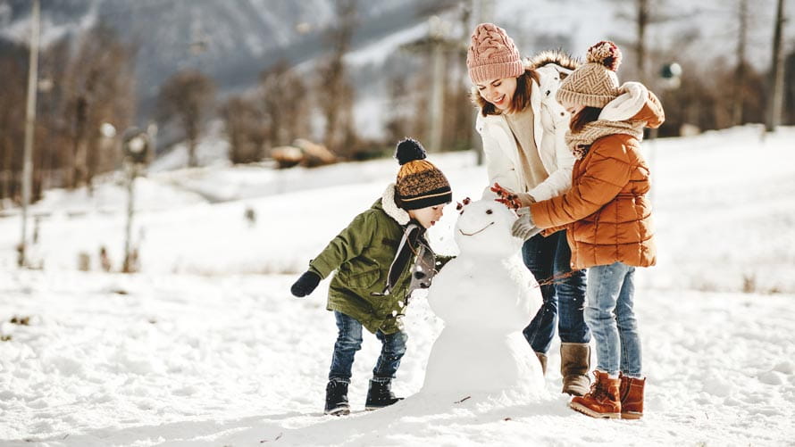 Mother and children building a snowman