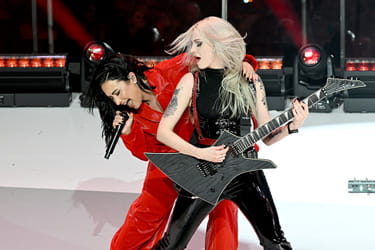 Demi Lovato performing at the Red Dress Collection Concert with the guitarist.