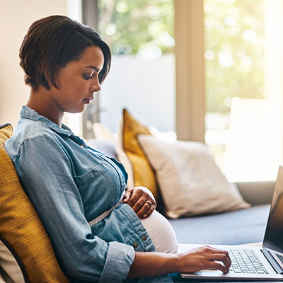 mujer embarazada usa una computadora portátil en el sofá mujer embarazada usa una computadora portátil en el sofá