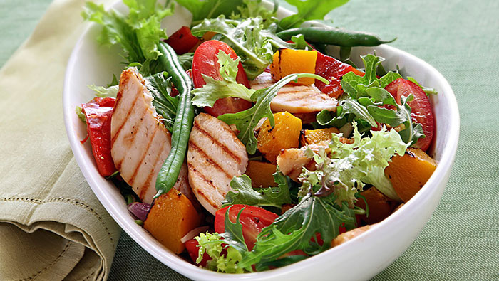 bowl of salad with grilled chicken and peaches