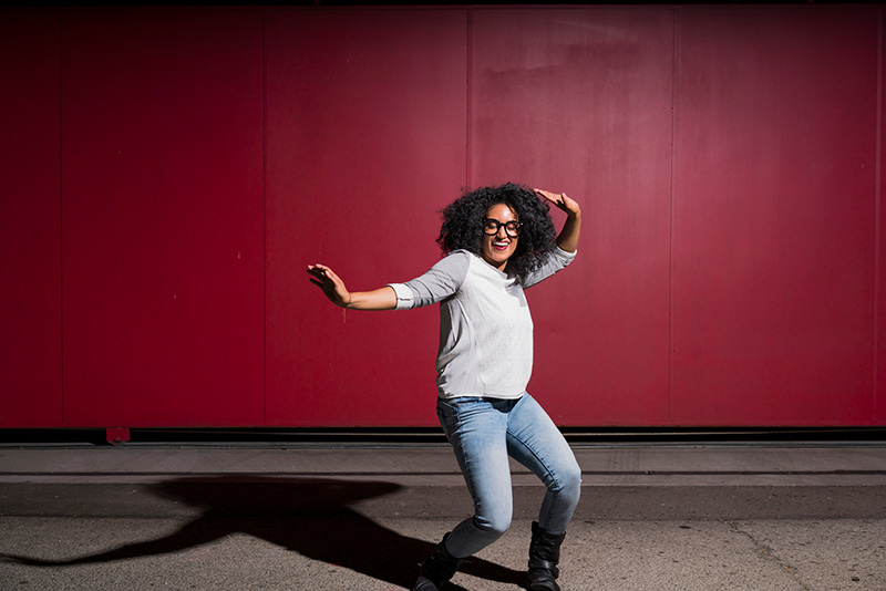 mujer feliz bailando sobre fondo rojo