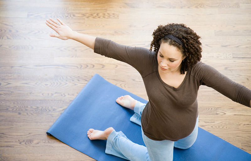 madre embarazada haciendo yoga