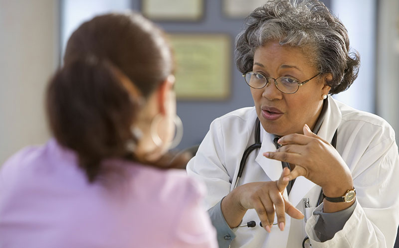 un médico de mediana edad asesora a un paciente