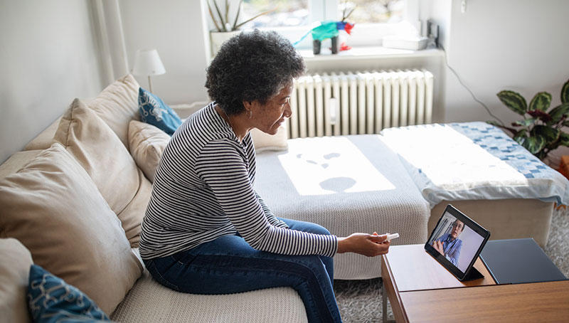 paciente mujer de mediana edad consulta con un doctor a través de la computadora portátil: telemedicina