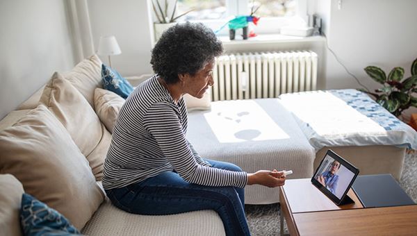 middle aged woman patient consults with doctor on laptop - telemedicine