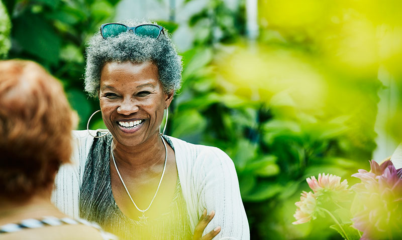 happy middle aged woman talking outdoors in sunlight