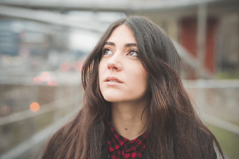 mujer de pelo largo contemplando la frágil naturaleza de la vida