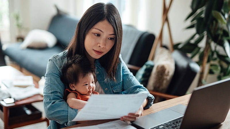 Mother with baby daughter working from home
