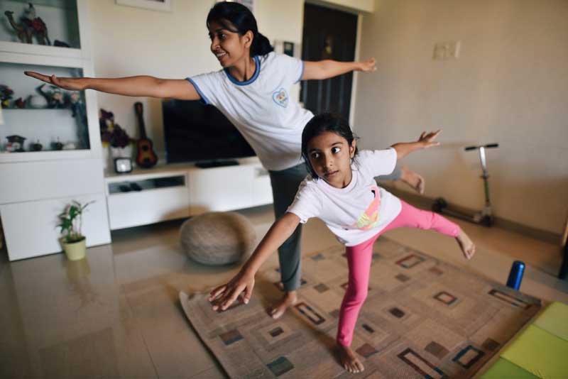 Madre e hija haciendo una postura de equilibrio de yoga