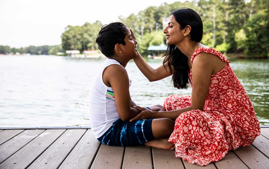 Mother and son chatting on a lake dock