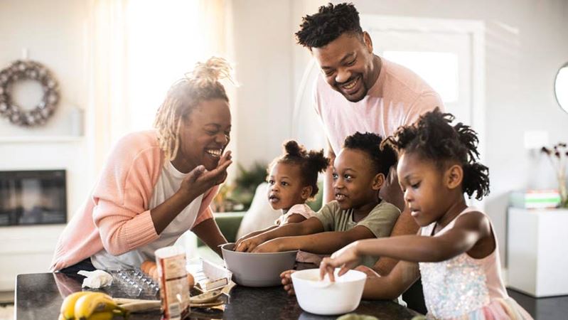 Familia mezclando masa de galletas en el hogar