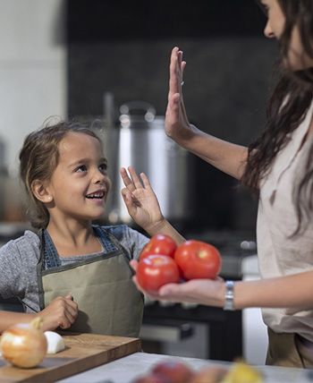 mamá e hija chocando los 5 mientras cocinan