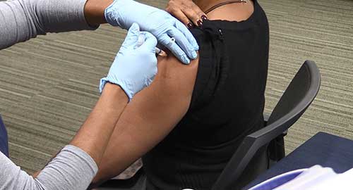 una mujer recibiendo la vacuna contra la gripe