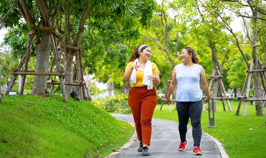 Two women walking at a park.