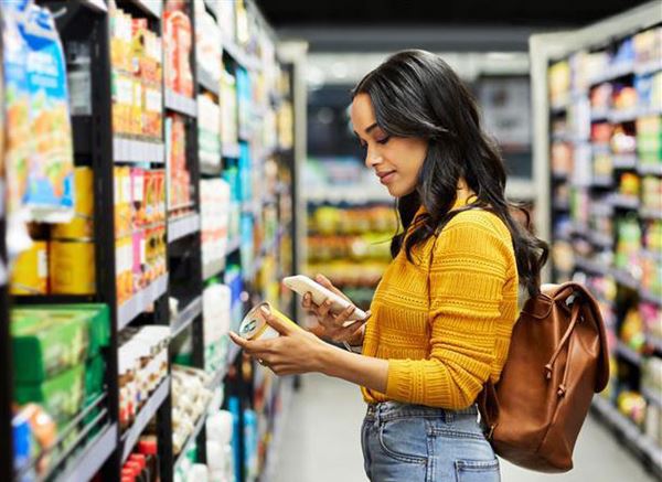 Young woman reading product list on phone and shopping.