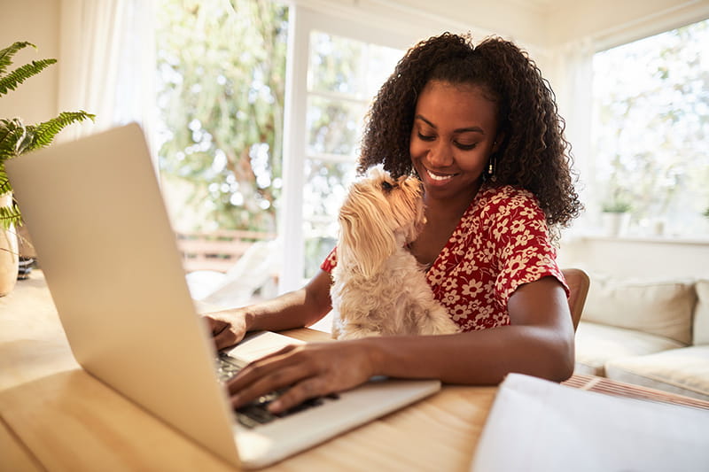 mujer usando su computadora portátil con su perro