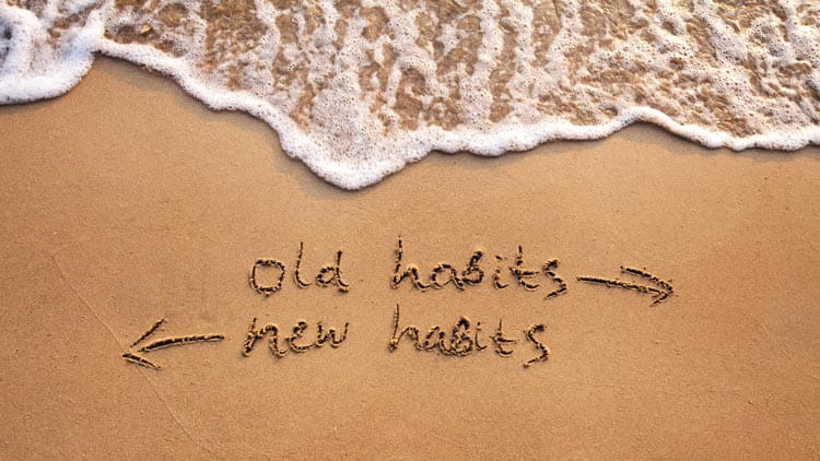 Old habits vs new habits, life change concept written on sand