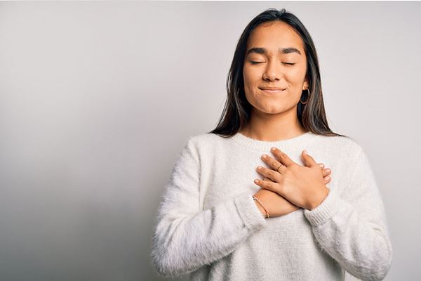 mujer agradecida con la mano sobre el corazón