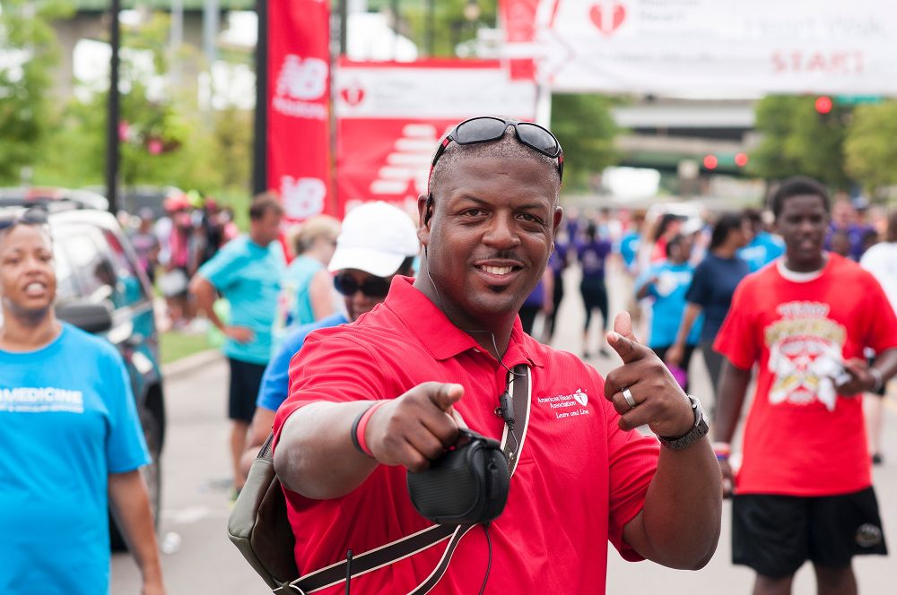 AHA Employee at Heart Walk pointing at the camera and grinning
