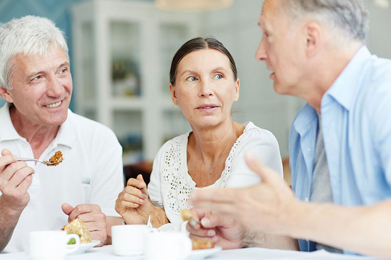 Personas mayores hablando durante el desayuno