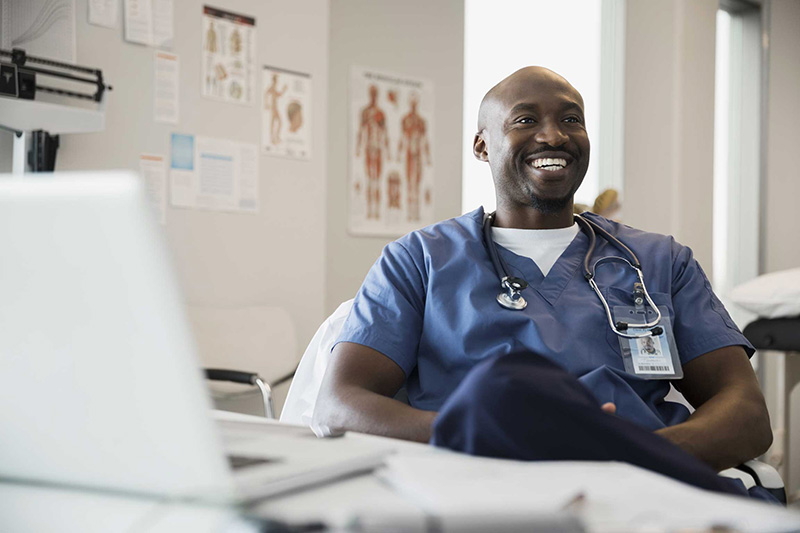 Smiling nurse sitting at a computer