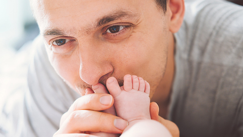 Padre besándole el pie a su bebé