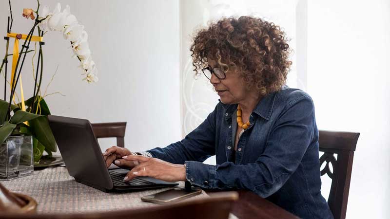 mujer buscando información en su computadora portátil