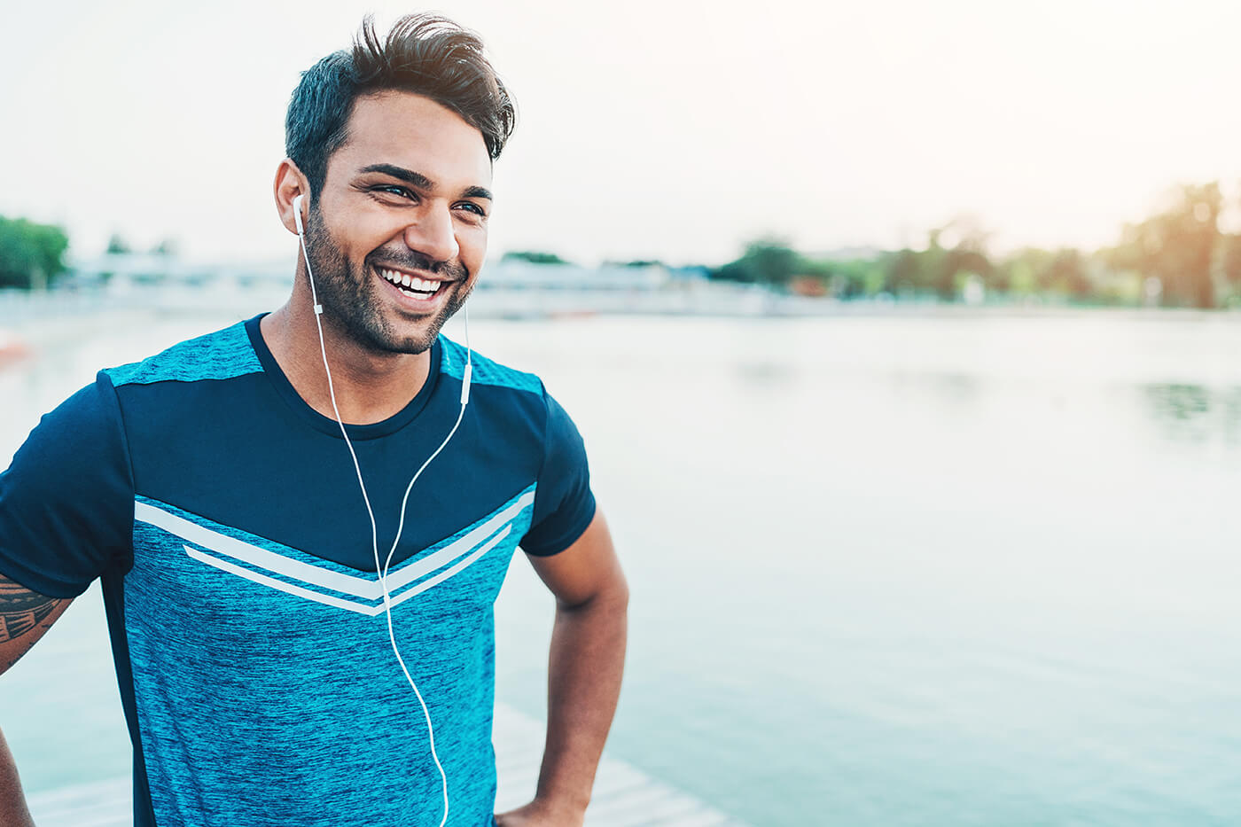 runner guy with earbuds in smiling laughing