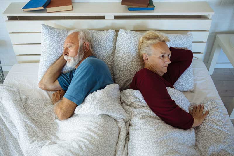 pareja de edad avanzada frustrada en la cama