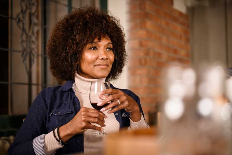 Older female drinking red wine