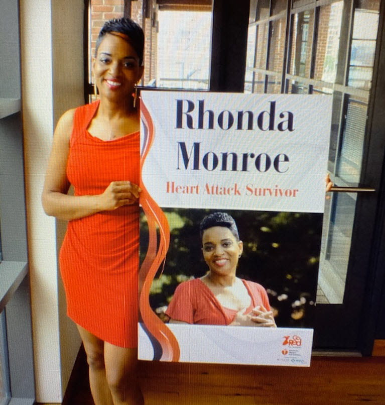 Rhonda holding Heart Attack Survivor sign at luncheon