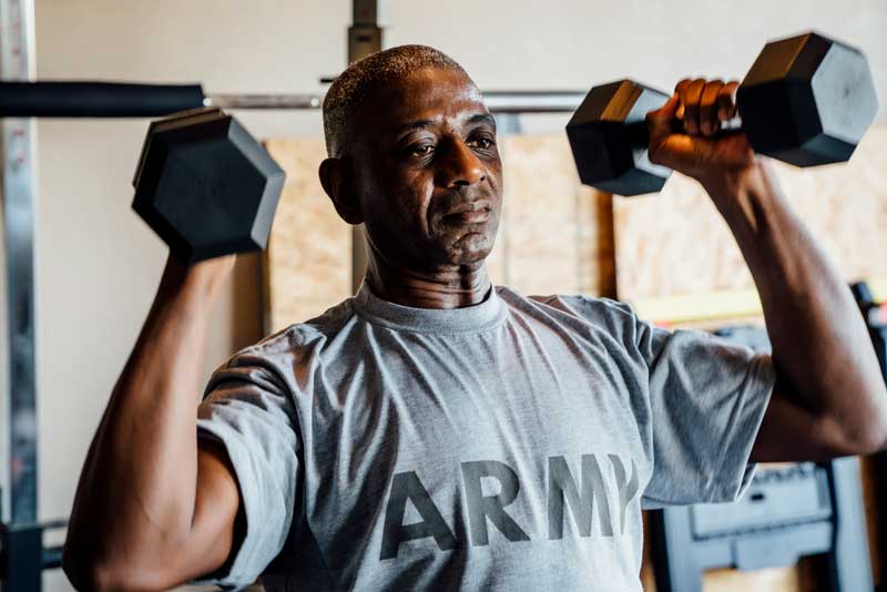 Military veteran lifting weights in garage