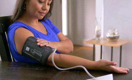 mujer revisando la presión arterial en el hogar