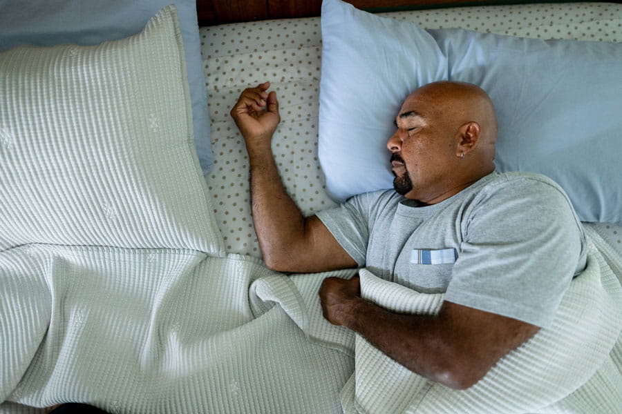 Man sleeping soundly in his bed