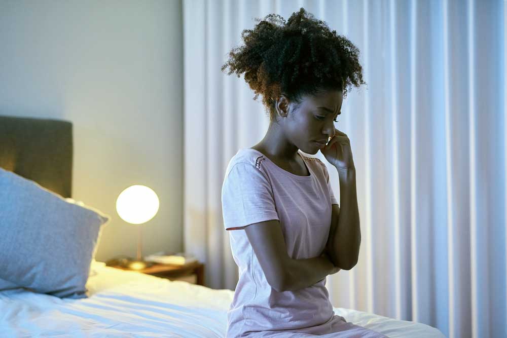 mujer frustrada sentada en su cama